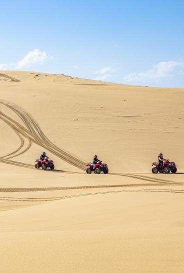 Small group enjoying an Aboriginal cultural tour on quad bikes with Sand Dune Adventures, Port Stephens